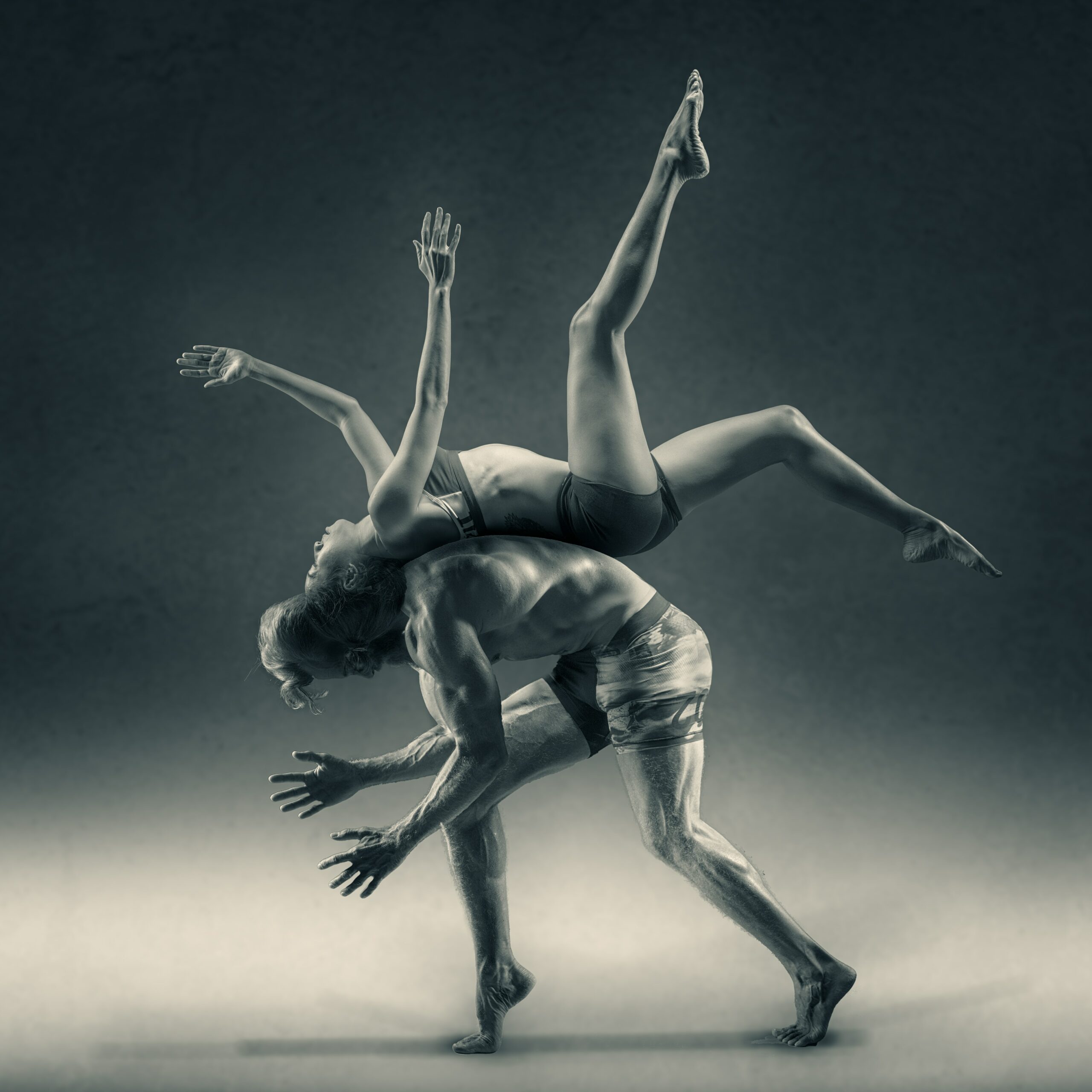 Two dancers of modern dance. One dancer bounces on the back of the other one